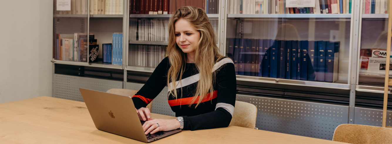 Meertens-onderzoeker aan tafel met een laptop.
